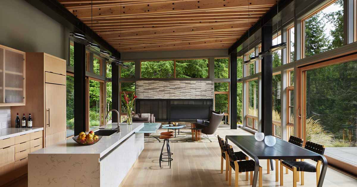 Warm wood and glass Pacific Northwest kitchen opening to the forest